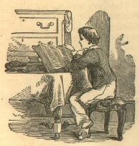 a boy reads at a table